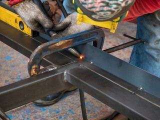 Professional welder welding metal and many fire sparks in the industrial workshop. welder welding...