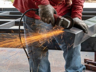 Close-up view of cutting steel shape, huge amount of sparks. Angle grinder sparks angle grinder cutting steel. Cutting steel with angle grinder. Worker cutting metal
