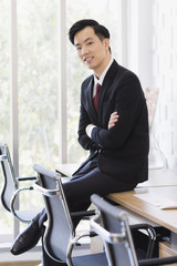 Asian Businessman sitting and posing in office..