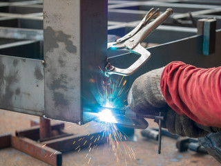 Professional welder welding metal and many fire sparks in the industrial workshop. welder welding...