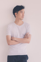Young Asian man model in T-shirt crossed arm..