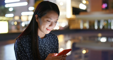 Woman read on smart phone in city at night