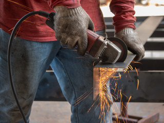 Close-up view of cutting steel shape, huge amount of sparks. Angle grinder sparks angle grinder cutting steel. Cutting steel with angle grinder. Worker cutting metal