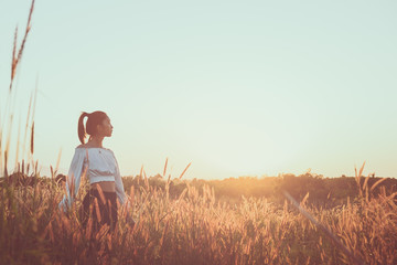 Beautiful young asian woman in a field with sunlight