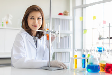 Fototapeta premium Scientist use stand to hold orange test tube..