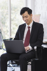 Asian Businessman using laptop in office..