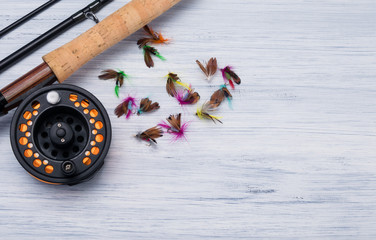 in the corner of the gray-white background table disassembled fishing rod with baits for fish