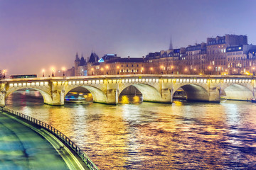 Fototapeta na wymiar Night view of Paris, France. Illuminated Pont neuf (New Bridge) is oldest bridge across the river Seine.