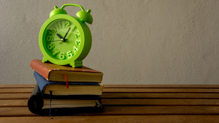 clock and books on wooden table