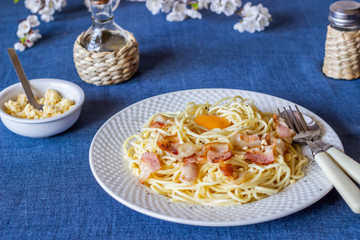 Pasta Carbonara. Flowers in the background. Italian food.