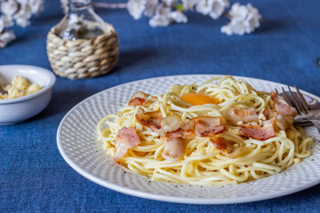 Pasta Carbonara. Flowers in the background. Italian food.