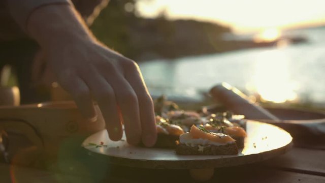 Salmon and cream cheese on bread. Picnic food by the beach. Beautiful sunset light