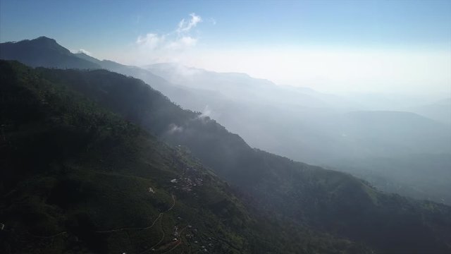 Aerial view of the green mountains and hills near the town of Haputale in Sri Lanka with clouds form in the sky over the mountain