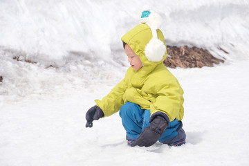 Fototapeta na wymiar Cute little Asian 2 - 3 years old toddler baby boy child wearing earmuff, snow gloves playing happily in snow, Family travel, Relax and fun winter vacation with child, winter season, Selective focus