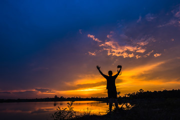 Silhouette photographer at sunset on the lake landscape