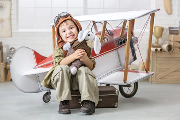 Little boy in the image of the pilot near the toy-plane