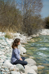 Young girl with positive emotions. Relaxed, pleased with a smile on her face. Spring natural background, forest and river.