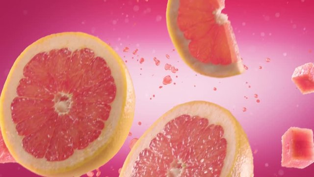 Grapefruit with Slices Falling on Pink Background