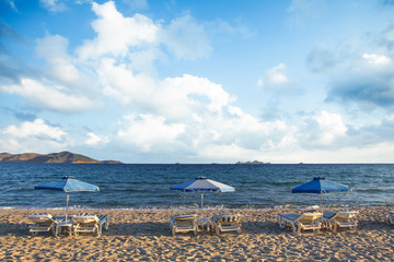 Sunshades on sandy beach sea with blue sky
