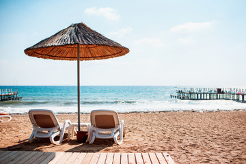 Sea sandy beach with the two deck chairs.