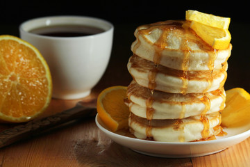 A stack of freshly backed pancakes and a cup of coffee