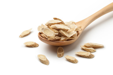 Sliced ​​of Astragalus (Huang Qi) in a wooden spoon, isolated on white background. Chinese...