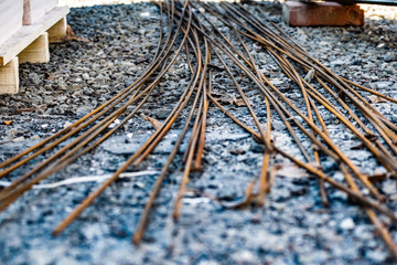 Rusty metal bars for concreting and building construction. Contraction of the structures. Materials on the gravel in the summer season.