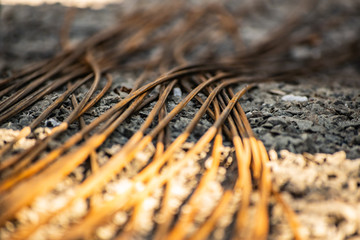 Rusty metal bars for concreting and building construction. Contraction of the structures. Materials on the gravel in the summer season.