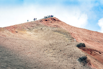 People walking on Mount Etna, active volcano on the east coast of Sicily, Italy.