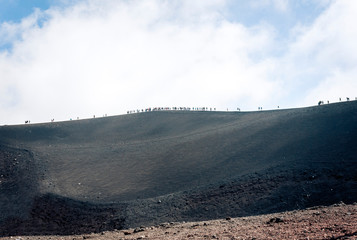 People walking on Mount Etna, active volcano on the east coast of Sicily, Italy.