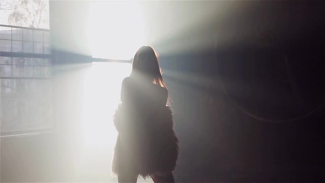 Fashionable girl in a fluffy pink coat, dancing and relaxing in the sun. Relax, disco.