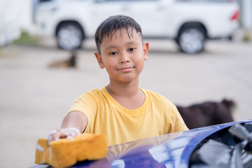 Asian kid boy washing car