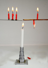 Classical physics experiment shows hat conduction. 3 red candles placed on a glass rod and a...