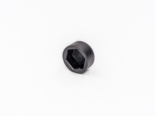 Black plastic hexagonal cover for nut shot on white.