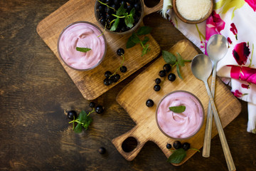 Homemade  black currant mousse on rustic wooden table. Delicious summer dessert. Copy space, top view flat lay background.