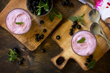 Homemade  black currant mousse on rustic wooden table. Delicious summer dessert. Top view flat lay background.