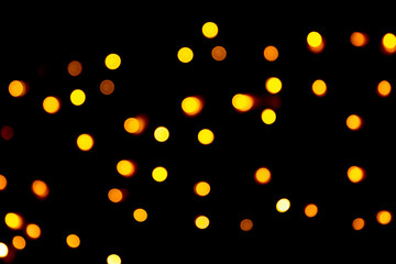 Unfocused abstract yellow bokeh on black background. defocused and blurred many round light