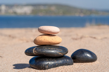 Obraz na płótnie Canvas Zen composition of pebbles on the sea sandy shore close up - summer holiday concept