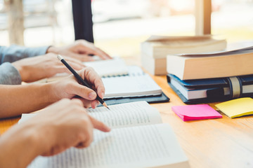 High school or college students studying and reading together in library