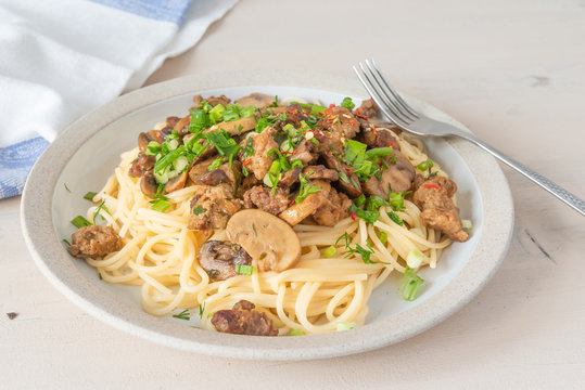 Spaghetti with homemade sausage and mushroom stew on a plate - traditional Italian pasta with Boscaiola mushroom sauce.