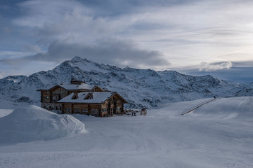 Downhill slope and apres ski mountain hut with restaurant terrace in the Italian Alps, Europe, Italy. Ski area Santa Caterina Valfurva