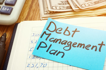 Debt management plan with calculator and cash.