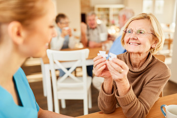 Senior Frau und eine Altenpflegerin beim Puzzle