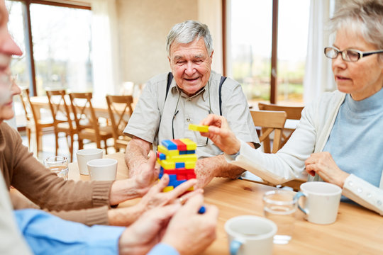 Senioren mit Demenz stapeln bunte Bausteine