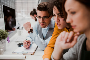 Group of young businesspeople working together in office, talking.