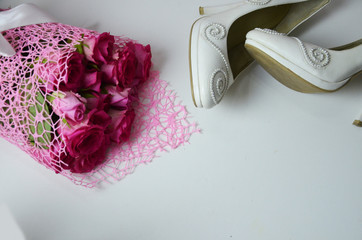wedding shoes and wedding bouquet of red pink roses