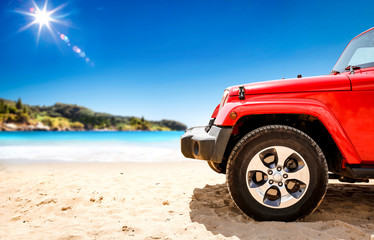 Fototapeta na wymiar Red summer car on beach and free space for your decoration. Summer sunny day and blue sky. 