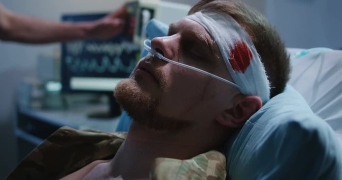Man lying in hospital bed with head injury