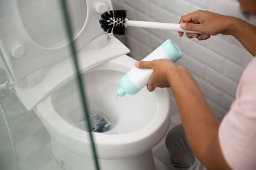 close up hand gesture cleaning toilet using brush