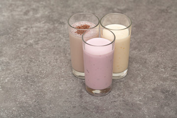 Assorted protein cocktails. Strawberry, banana and chocolate protein shakes. Sports nutrition and healthy lifestyle concept.